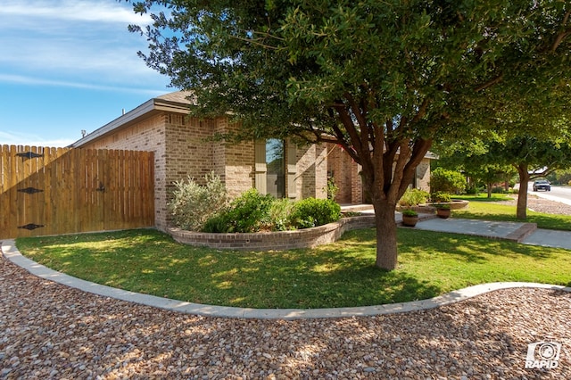 view of side of property with brick siding and a gate