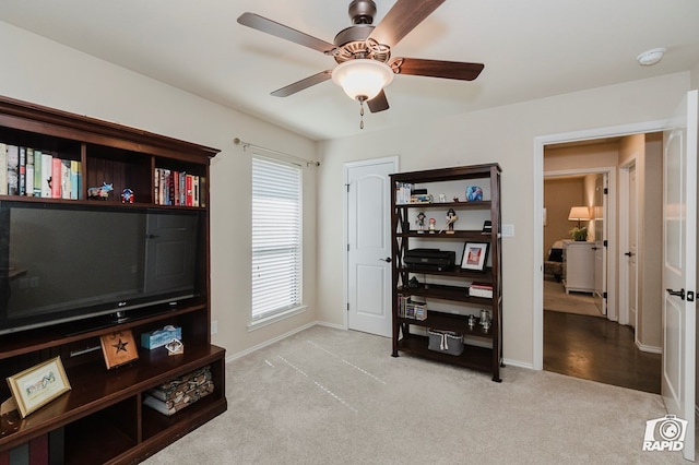 living area featuring carpet flooring, baseboards, and ceiling fan