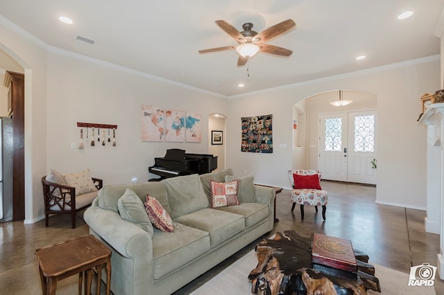 living room featuring arched walkways, ceiling fan, crown molding, baseboards, and recessed lighting