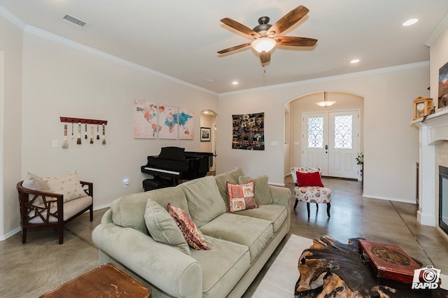 living room with arched walkways, baseboards, ornamental molding, recessed lighting, and a ceiling fan