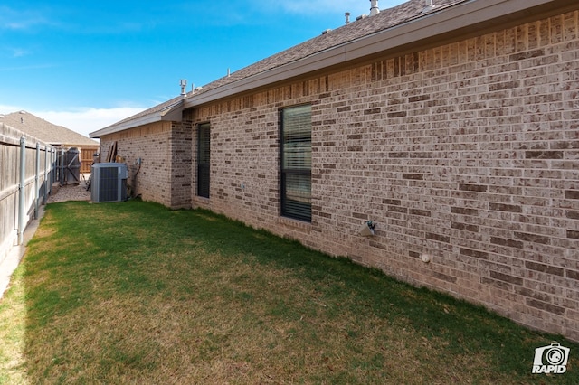 view of side of property featuring central AC and brick siding