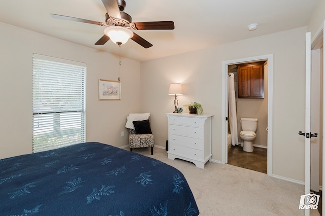bedroom featuring carpet flooring, baseboards, ensuite bathroom, and ceiling fan