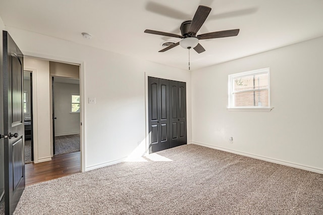 unfurnished bedroom featuring ceiling fan and dark colored carpet