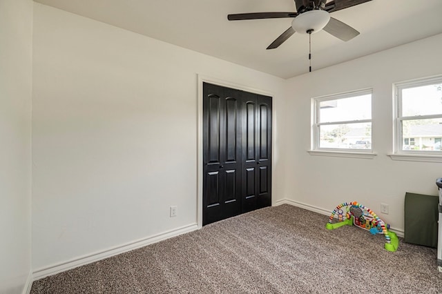 unfurnished bedroom featuring ceiling fan, a closet, and carpet floors