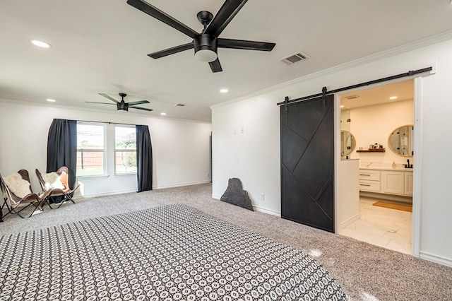 unfurnished bedroom featuring ceiling fan, a barn door, crown molding, and ensuite bathroom