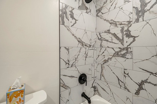 bathroom featuring toilet and tiled shower / bath combo