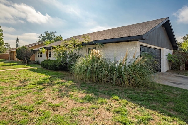 view of side of home with a lawn and a garage