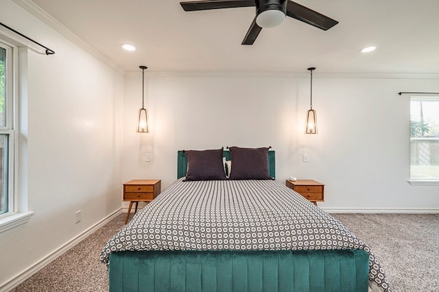 carpeted bedroom featuring ceiling fan and crown molding