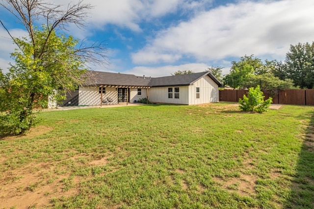 rear view of property featuring a patio area and a lawn