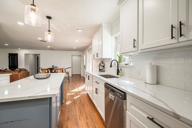 kitchen featuring white cabinetry, pendant lighting, stainless steel dishwasher, and sink