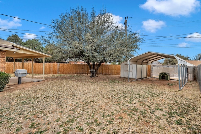 view of yard with a carport and a fenced backyard