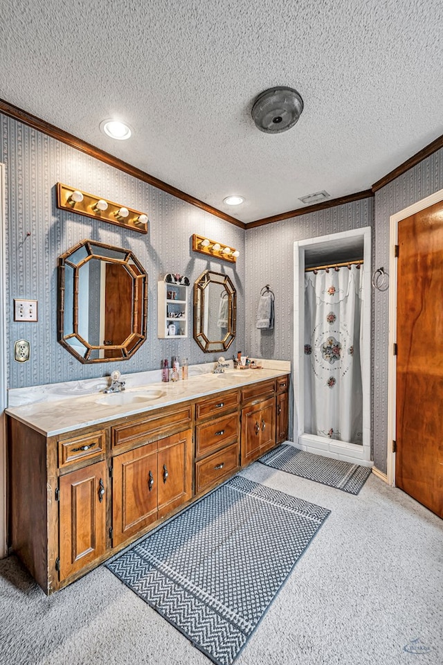 full bathroom featuring double vanity, crown molding, a textured ceiling, a shower stall, and a sink