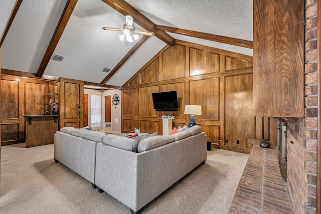 living area featuring visible vents, vaulted ceiling with beams, wood walls, and a textured ceiling