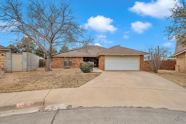 single story home with brick siding, a shingled roof, concrete driveway, an attached garage, and fence