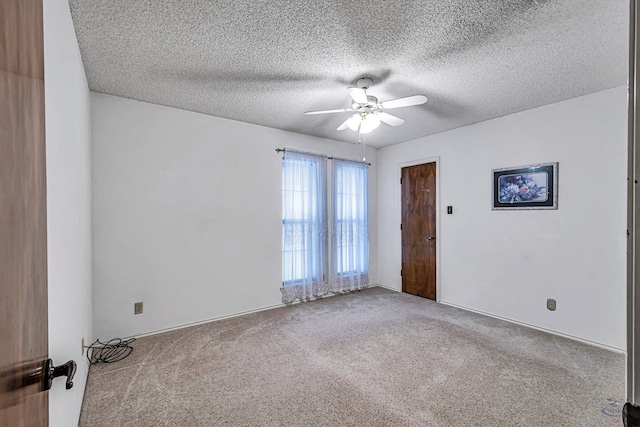 carpeted empty room with ceiling fan and a textured ceiling