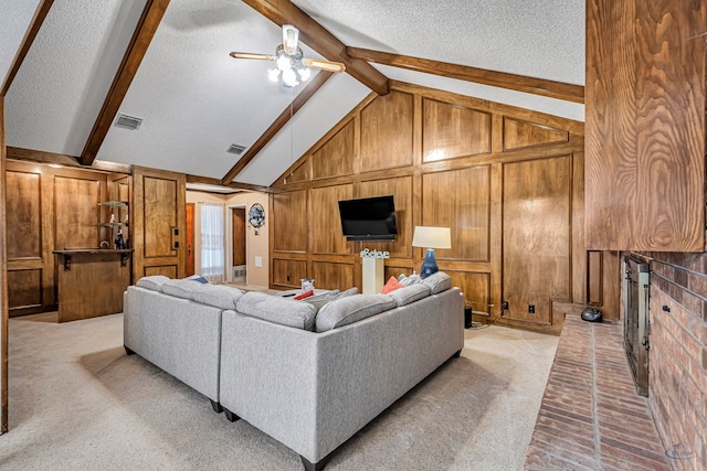 living room with vaulted ceiling with beams, a textured ceiling, wood walls, a fireplace, and visible vents