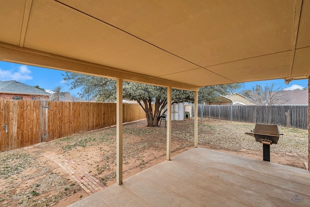 view of patio featuring a storage shed, an outbuilding, and a fenced backyard