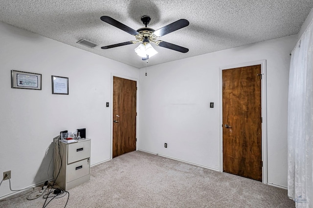 bedroom with a textured ceiling, ceiling fan, visible vents, and light colored carpet