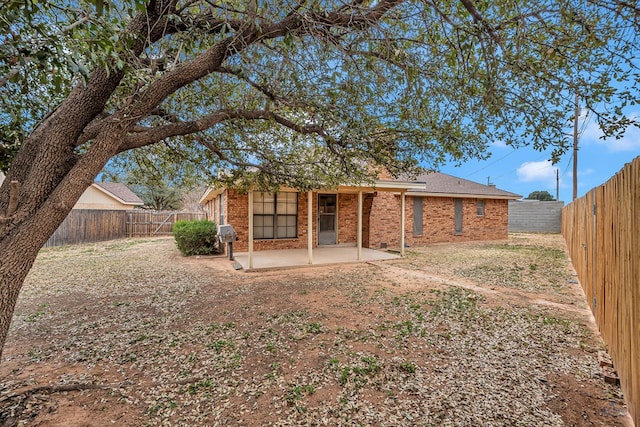 back of property with brick siding, a fenced backyard, and a patio