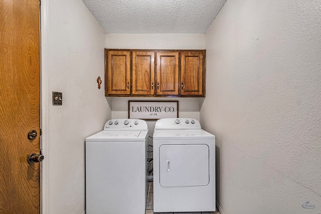 laundry area featuring cabinet space, a textured ceiling, washer and dryer, and a textured wall