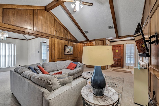 living room featuring beamed ceiling, visible vents, and light colored carpet