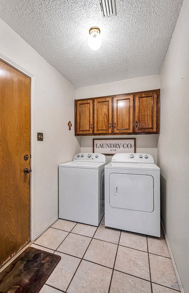 washroom with cabinet space, light tile patterned floors, visible vents, a textured ceiling, and separate washer and dryer