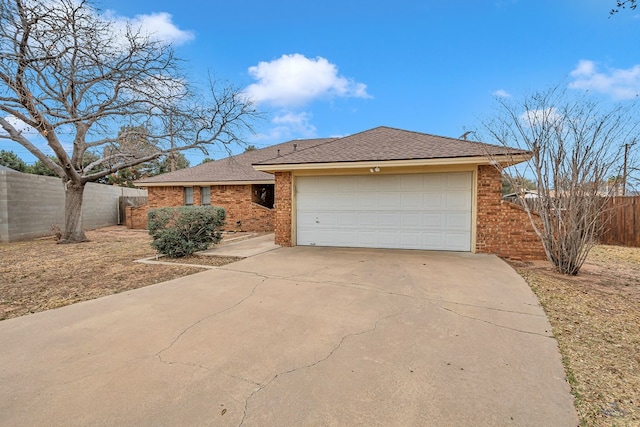 ranch-style home with driveway, fence, and brick siding