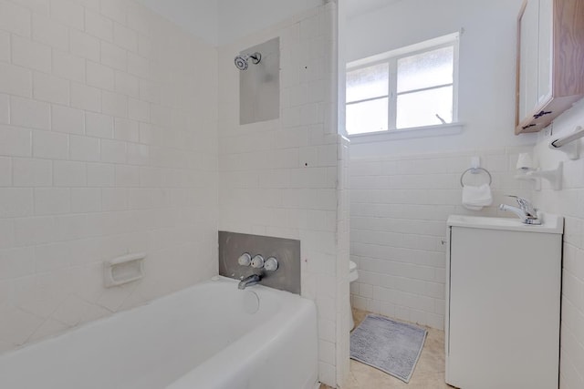 bathroom featuring toilet, a wainscoted wall, tile patterned floors, vanity, and tile walls