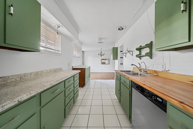 kitchen with stainless steel dishwasher, light tile patterned flooring, a sink, and green cabinetry