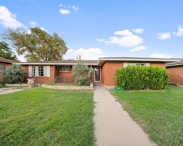 single story home featuring brick siding and a front yard