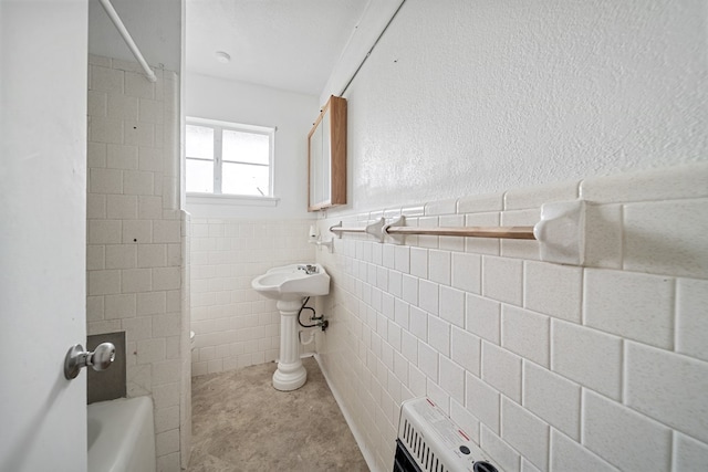 bathroom with  shower combination, wainscoting, and tile walls