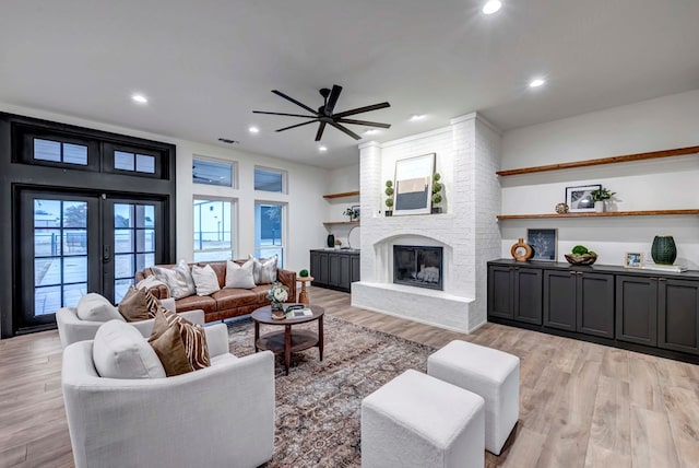 living room featuring a fireplace, light hardwood / wood-style floors, and french doors