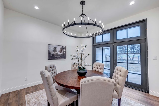 dining room with hardwood / wood-style flooring, a chandelier, and french doors