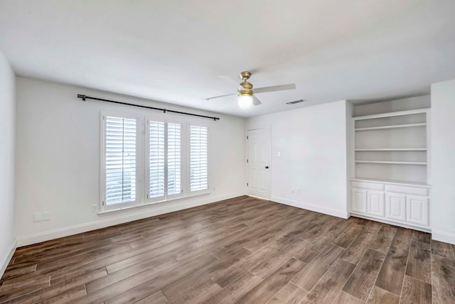 empty room featuring dark wood-type flooring and ceiling fan