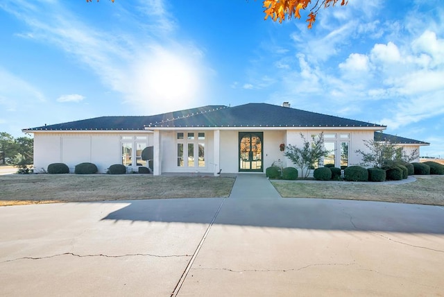 view of front of house featuring a front yard and french doors