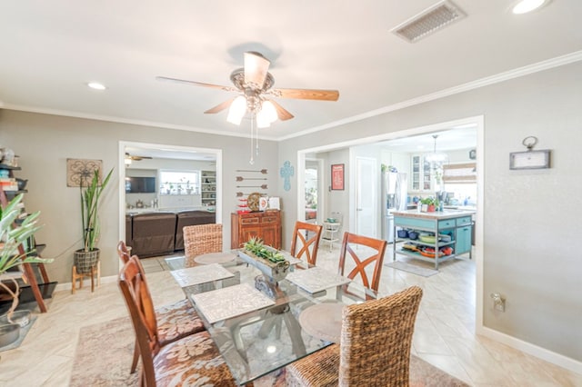 dining space with ceiling fan and crown molding