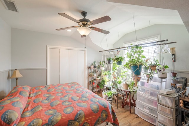 bedroom with ceiling fan, a closet, light hardwood / wood-style flooring, and lofted ceiling