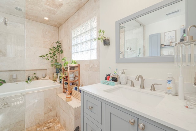 bathroom with tiled tub and vanity