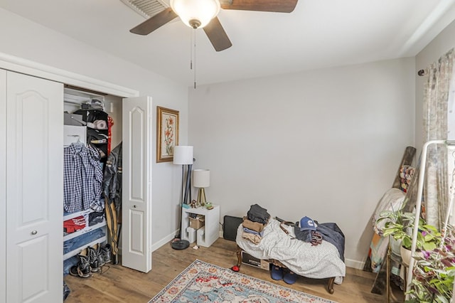 bedroom with light wood-type flooring, ceiling fan, and a closet