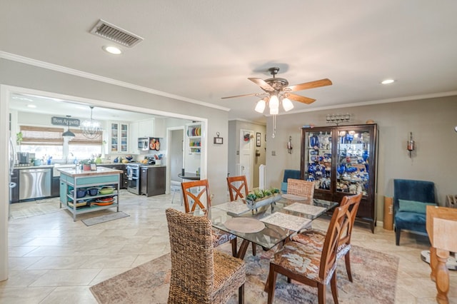 dining room with light tile patterned floors, ornamental molding, ceiling fan with notable chandelier, and sink