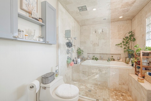 bathroom featuring tiled bath and toilet