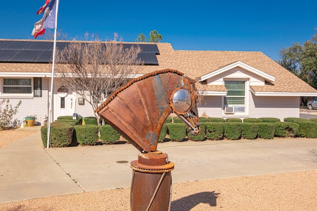 view of front of home with cooling unit and solar panels