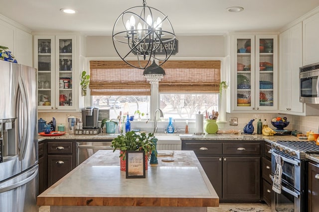 kitchen featuring backsplash, white cabinetry, appliances with stainless steel finishes, and a center island