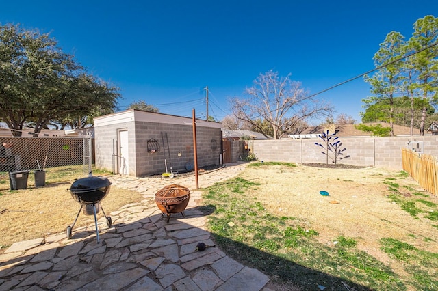 view of yard featuring an outdoor fire pit and an outdoor structure