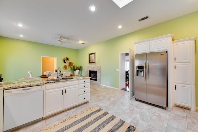 kitchen with dishwasher, stainless steel fridge with ice dispenser, white cabinetry, and sink