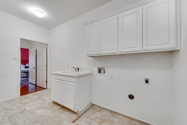 clothes washing area with electric dryer hookup, cabinets, sink, hookup for a washing machine, and a textured ceiling