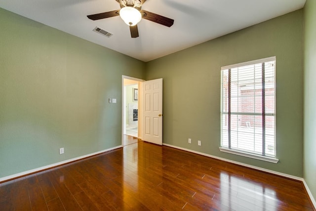 unfurnished room featuring dark hardwood / wood-style floors, ceiling fan, and a wealth of natural light