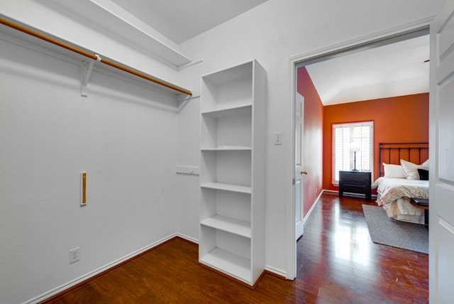 walk in closet with dark hardwood / wood-style flooring and lofted ceiling