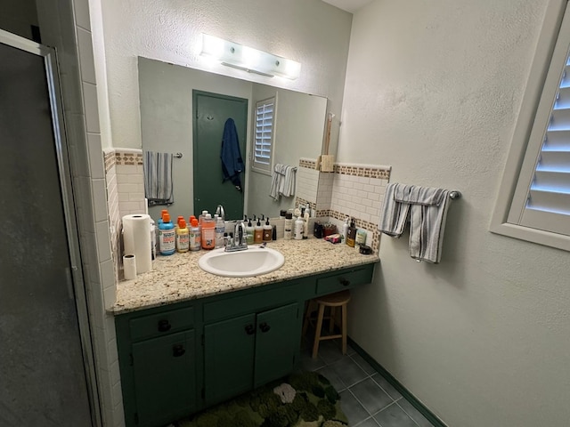 2408 Camarie Ave, Midland, TX 79705 - bathroom featuring tile patterned floors, vanity, and a stall shower
