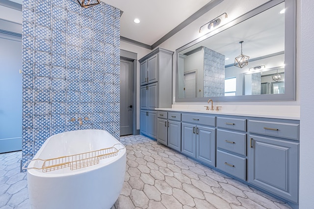bathroom featuring a freestanding bath, vanity, and recessed lighting